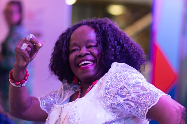 A woman wearing a white top smiling and dancing. Credit Ines Yearwood-Sanchez.