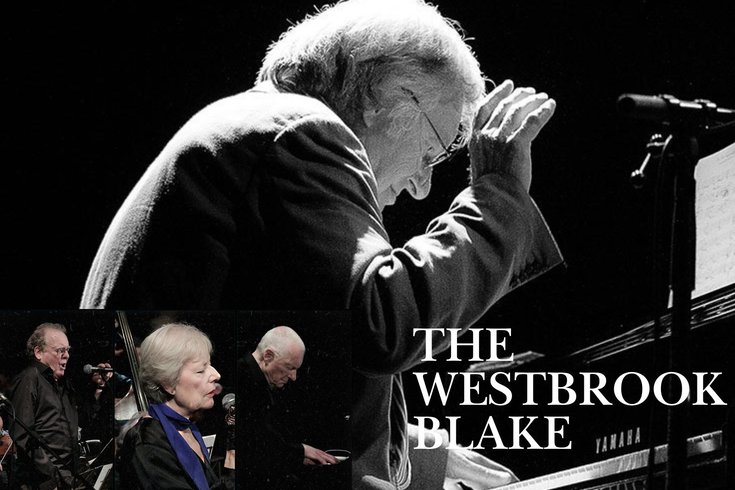 Male playing the piano, with a female and male singing into a microphone