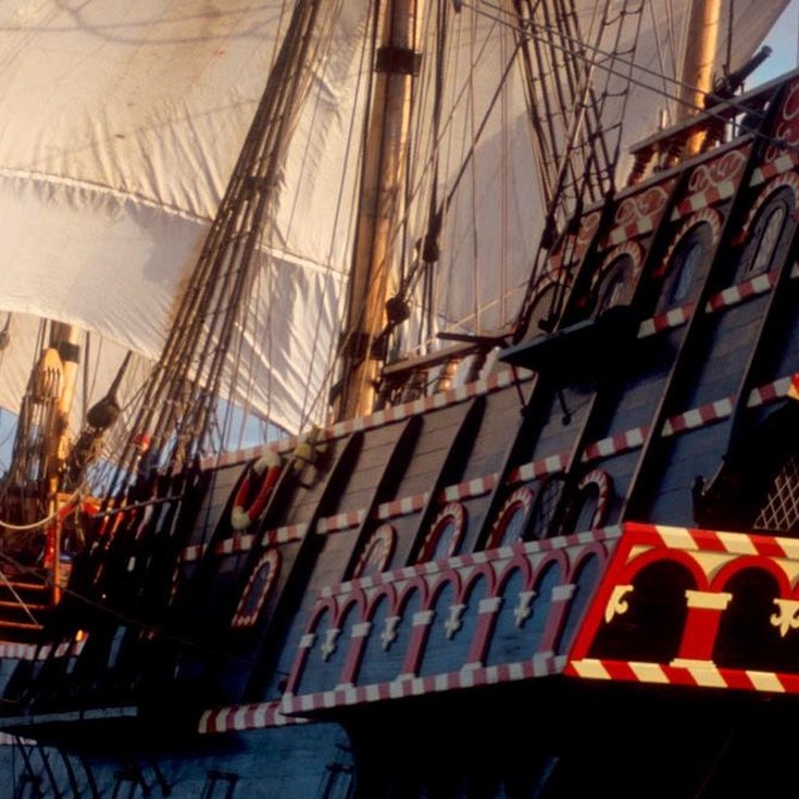 Promotional image of The Golden Hinde, the famous ship, out at sea with the wind in her sails.