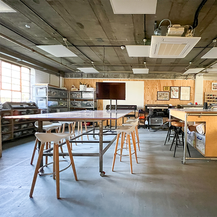 Materialise Workshop Space at Blue Garage - big windows, stools, and a chipboard wall in a maker space