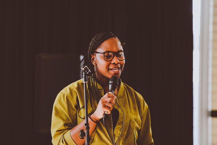 A young person sings into a mic.
