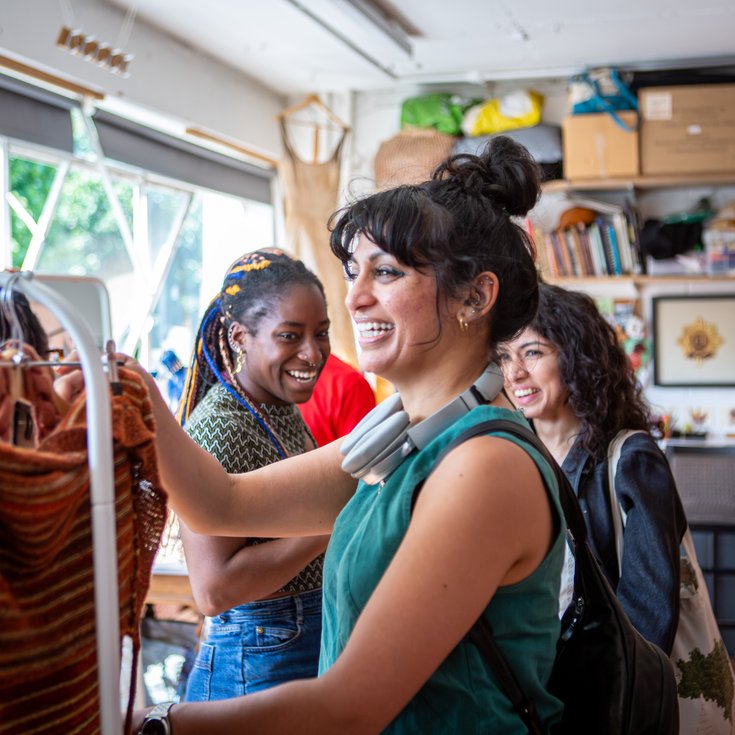 Visitors smiling while browsing textiles at Cockpit Open Studios