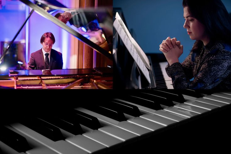 A female sits at the piano with her hands together. A male sits at a grand piano wearing a suit.
