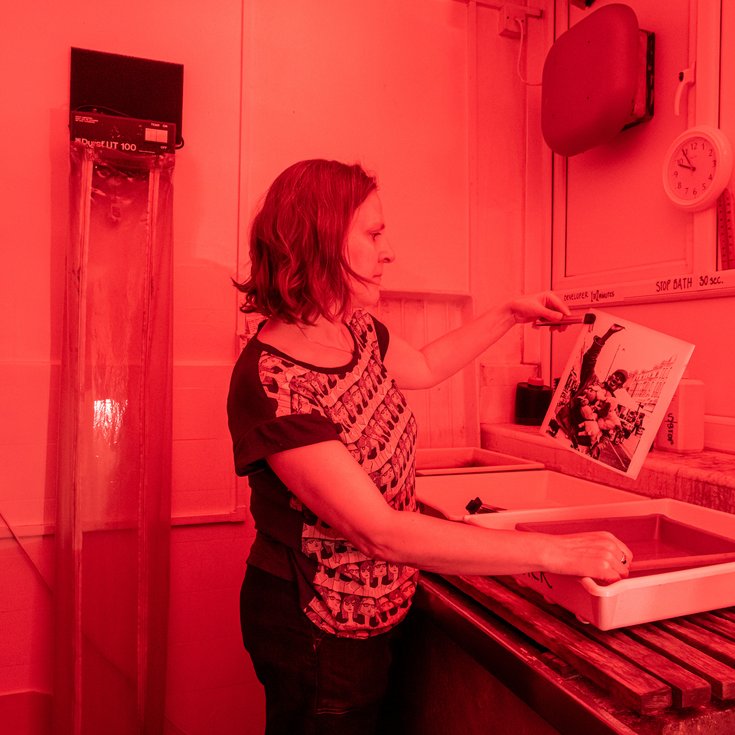 Someone developing a photograph in a darkroom