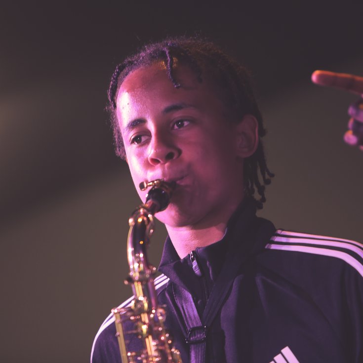 A young musician plays the saxophone