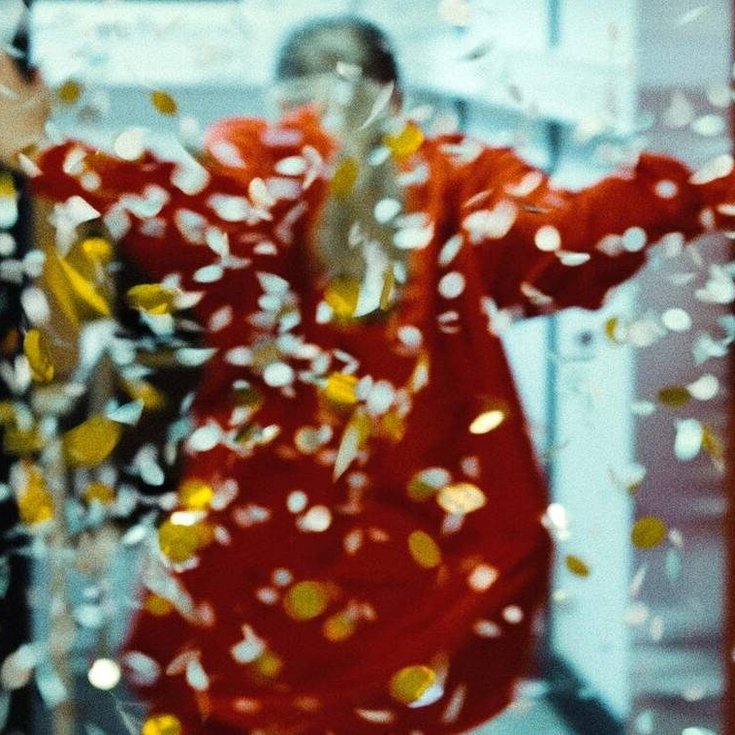 A person with their back facing the camera. Confetti is falling from above.