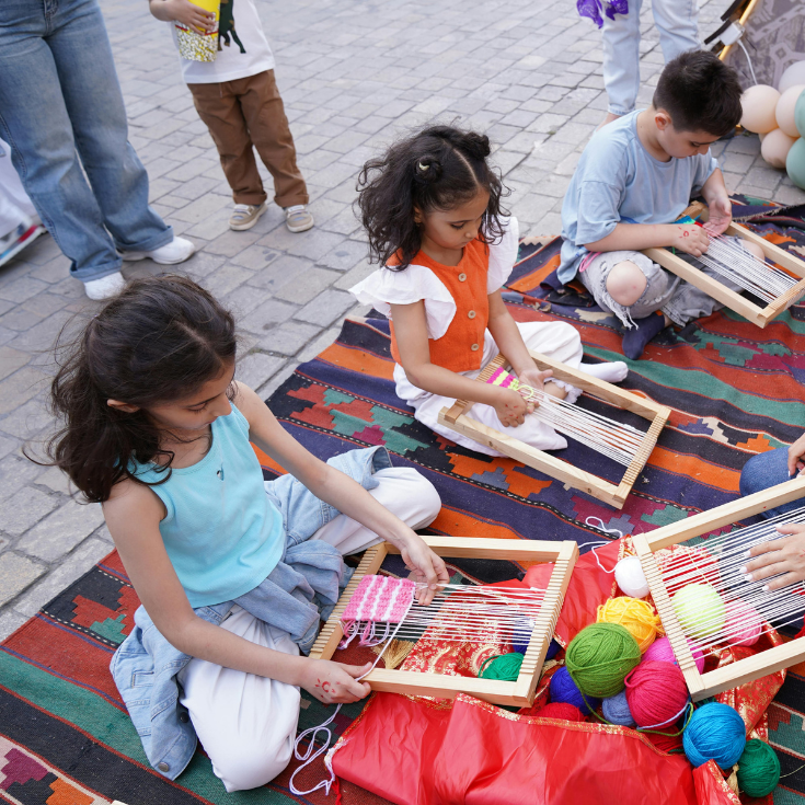 Children doing arts and crafts on outdoor rug