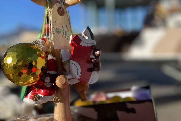 Christmas decorations on a wooden stand, with the Horniman Bandstand in the background against a blue sky