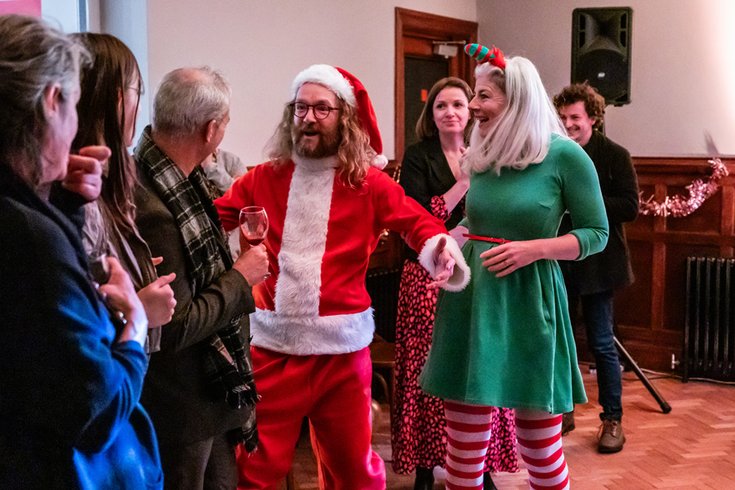 Santa and an elf greeting the guests