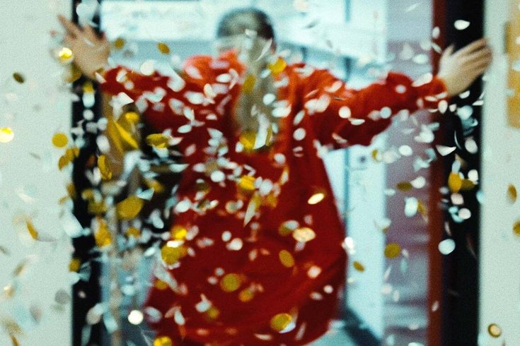 A person with their back facing the camera. Confetti is falling from above.