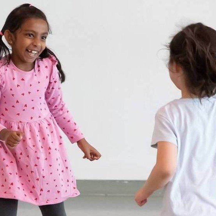 Two young children dancing.