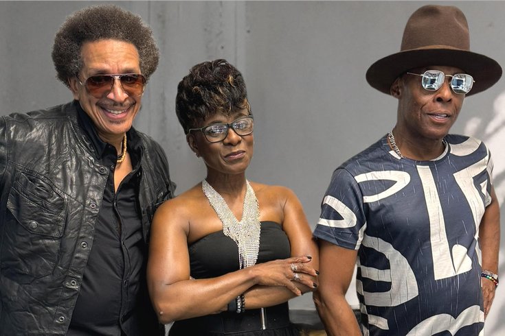 The stylish members of Loose Ends pose confidently. One in a leather jacket and sunglasses, another in a sparkling top, and the third in a patterned shirt and wide-brimmed hat.