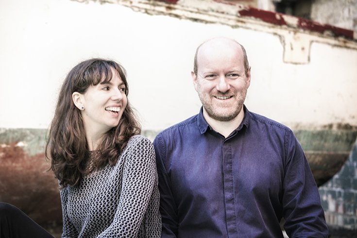 A female and male sitting and smiling
