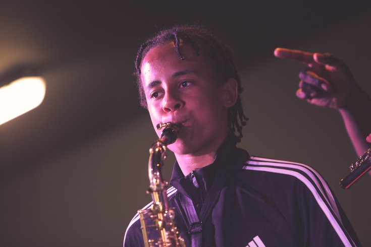 A young musician plays the saxophone
