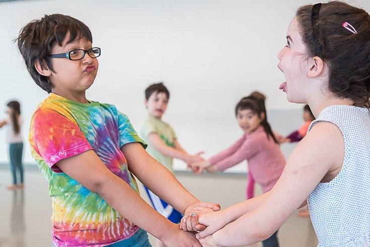 A group of young children holding hands.