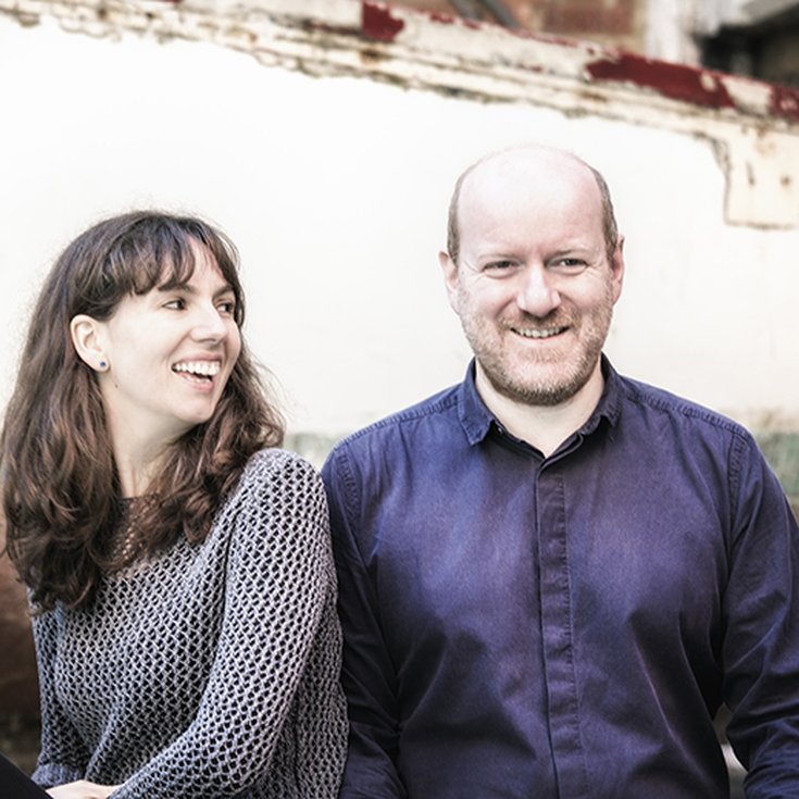 A female and male sitting and smiling