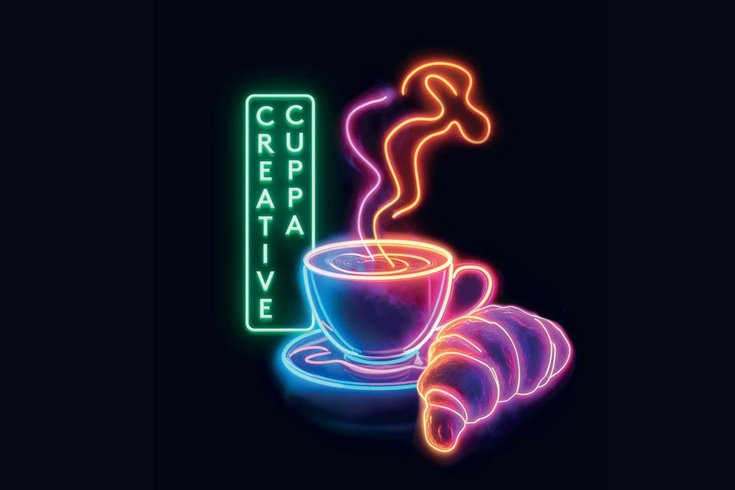 A neon sign with a coffee, croissant and text reading 'Creative Cuppa'