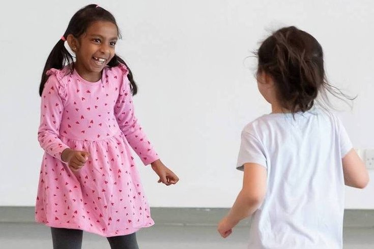 Two young children dancing.