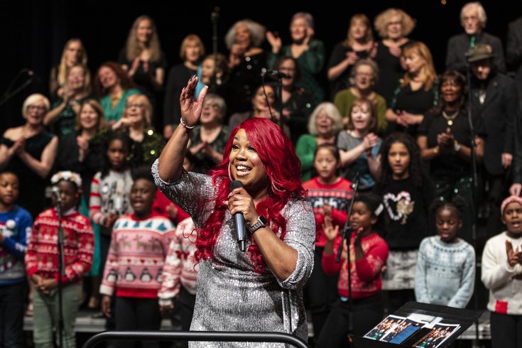 Lots of people of all different ages performing wearing festive jumpers