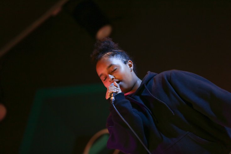 A young person sings into the mic