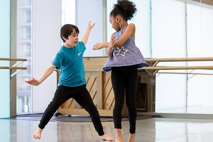 Two young children dancing.