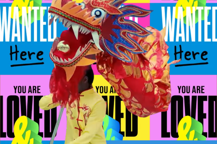Dragon dancer with the head of the dragon, behind are Love & Wanted posters to mark the occasion. Everyone is love and wanted here.