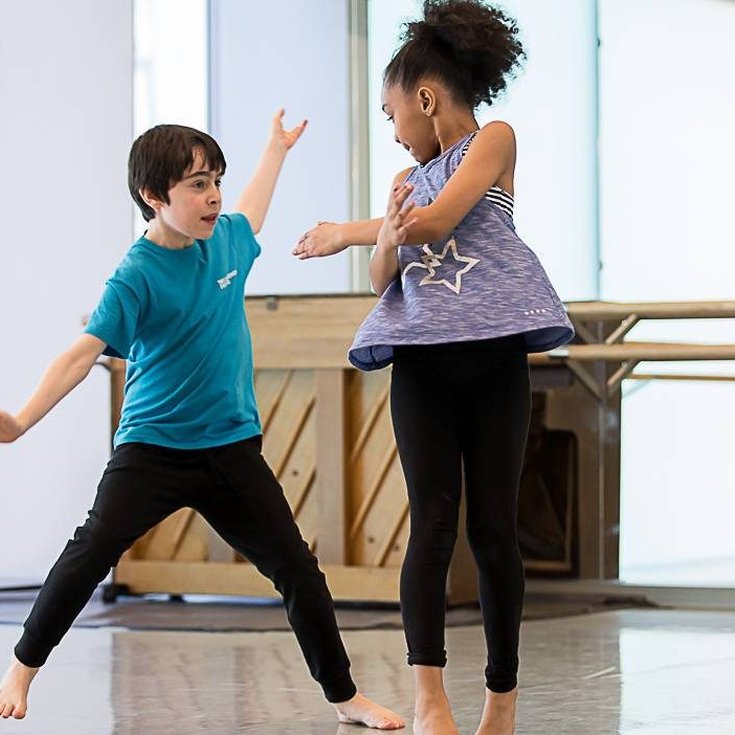 Two young children dancing.