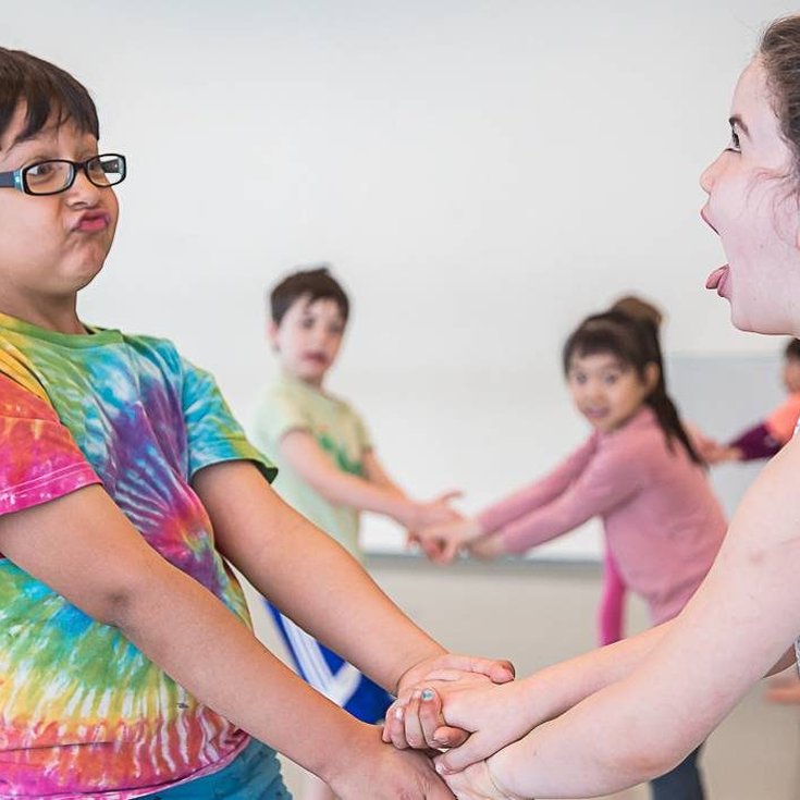 A group of young children holding hands.